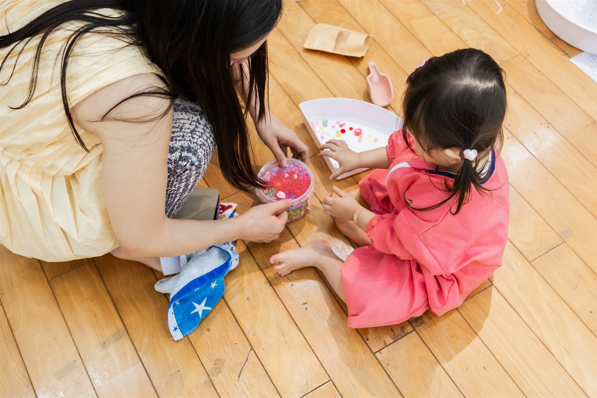 床で一緒に遊ぶママと子ども