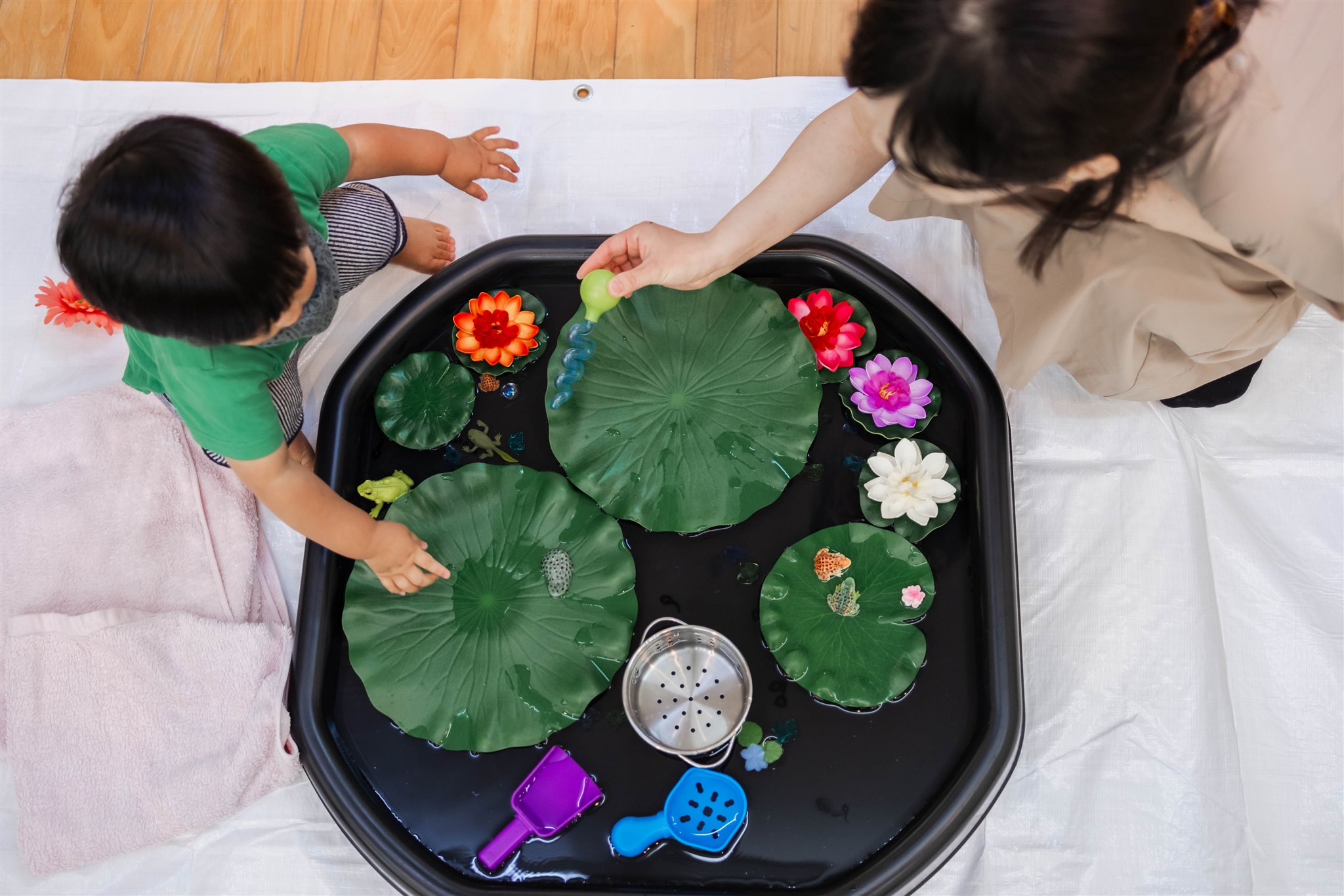 蓮の葉のトレイで遊ぶ親子の手元